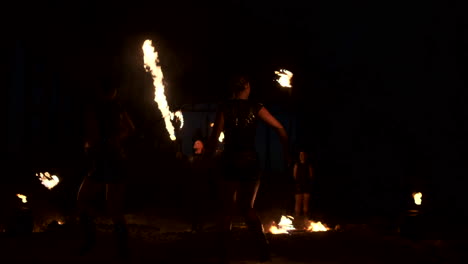 Professional-fire-show-in-the-old-hangar-of-the-aircraft-show-professional-circus-artists-three-women-in-leather-suits-and-a-man-with-two-flamethrowers..